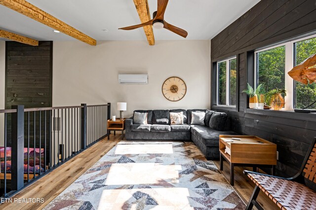 interior space with hardwood / wood-style floors, ceiling fan, a wall unit AC, and wooden walls