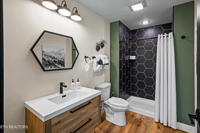 bathroom with vanity, toilet, a shower with shower curtain, and wood-type flooring