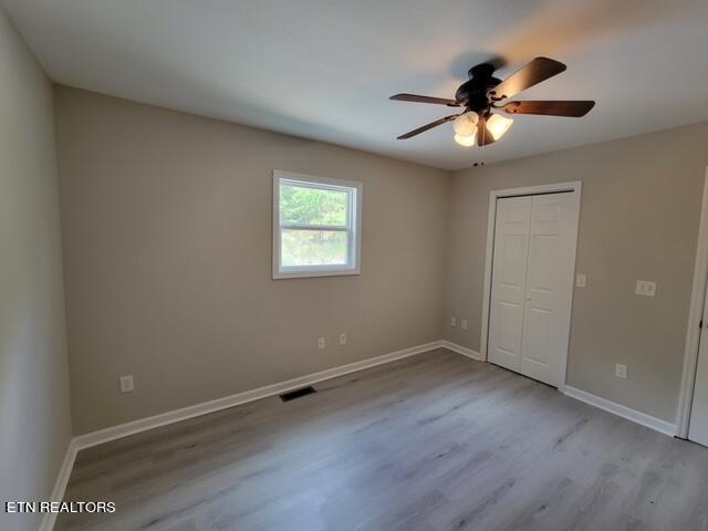 unfurnished bedroom with a closet, ceiling fan, and hardwood / wood-style floors