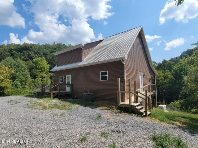 rear view of house featuring cooling unit