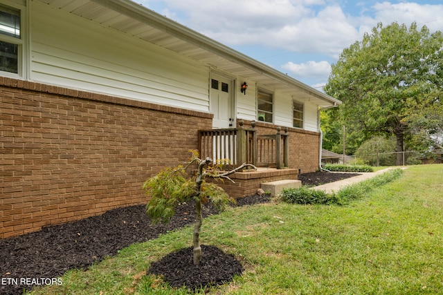 view of exterior entry featuring a yard