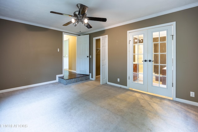 carpeted empty room with ceiling fan, a wealth of natural light, crown molding, and french doors