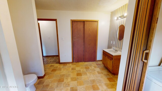 bathroom featuring vanity, toilet, and a textured ceiling