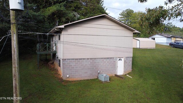 view of home's exterior with a yard, an outbuilding, and a garage