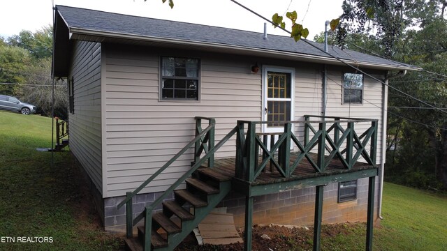 rear view of property featuring a lawn