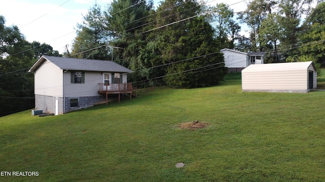 view of yard with central AC, a storage shed, and a deck