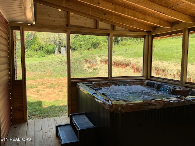 unfurnished sunroom featuring wooden ceiling, lofted ceiling with beams, a healthy amount of sunlight, and a hot tub