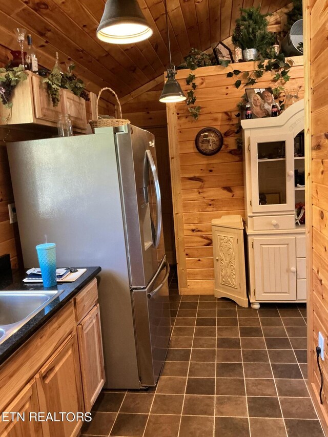 kitchen with wood walls, dark tile patterned flooring, vaulted ceiling, and wooden ceiling