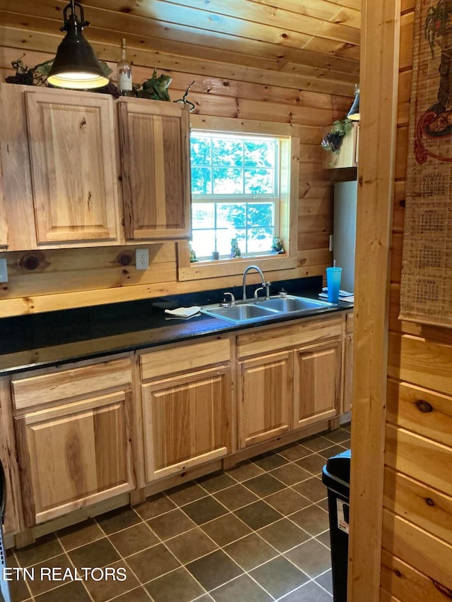 kitchen with wooden ceiling, dark tile patterned floors, sink, and wooden walls