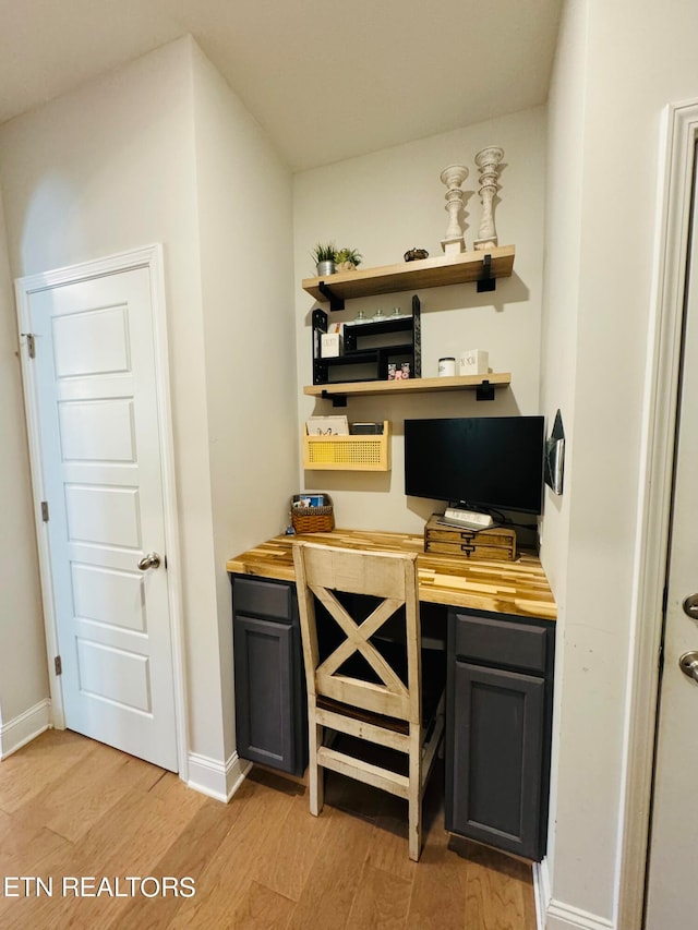 bar featuring butcher block countertops and light hardwood / wood-style floors