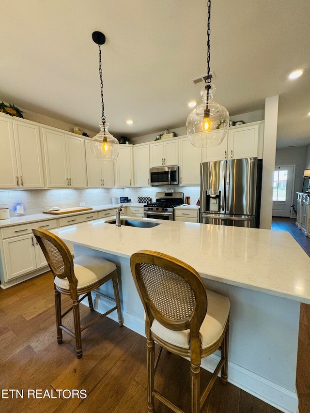 kitchen with hanging light fixtures, white cabinets, stainless steel appliances, and dark hardwood / wood-style floors