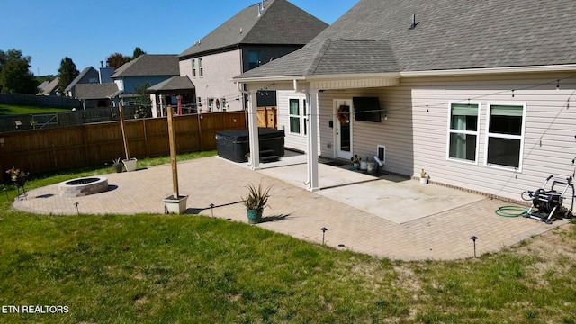 back of property with a patio area, a yard, and a fire pit