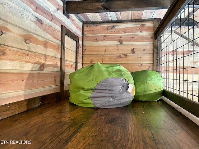 interior details with beam ceiling, wood-type flooring, wooden ceiling, and wooden walls