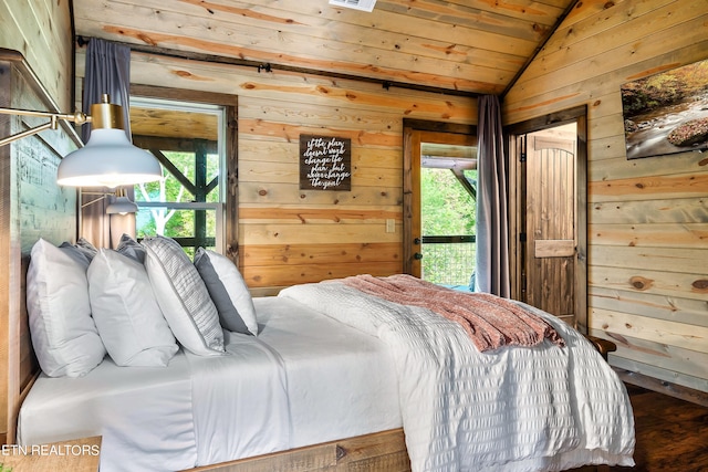 bedroom featuring lofted ceiling, wood walls, multiple windows, and access to exterior