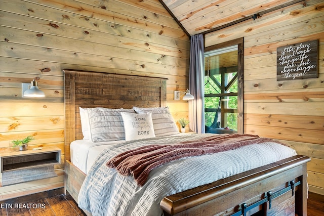 bedroom with lofted ceiling, dark hardwood / wood-style floors, and wooden walls