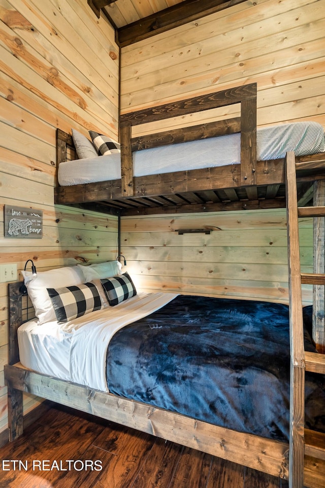 bedroom featuring wood-type flooring and wooden walls