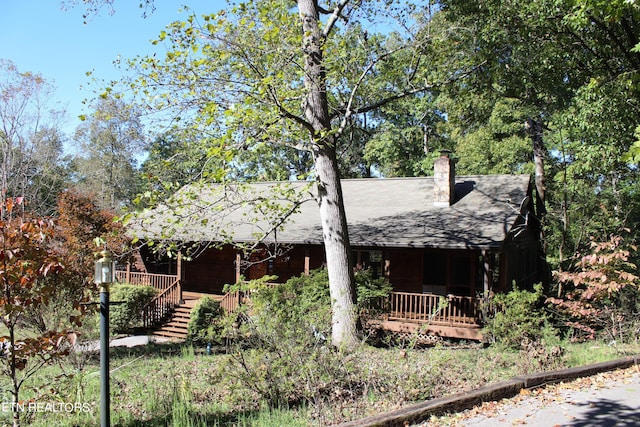 view of side of home featuring covered porch