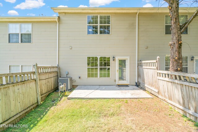 back of house featuring central AC unit, a patio area, and a lawn