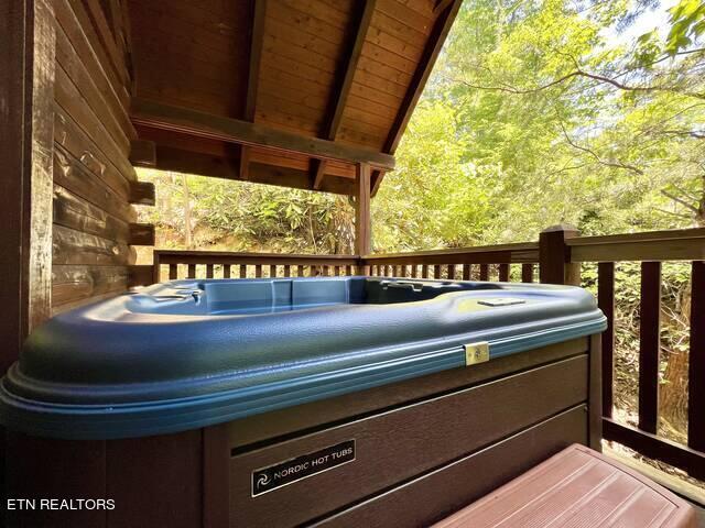 wooden deck featuring a hot tub