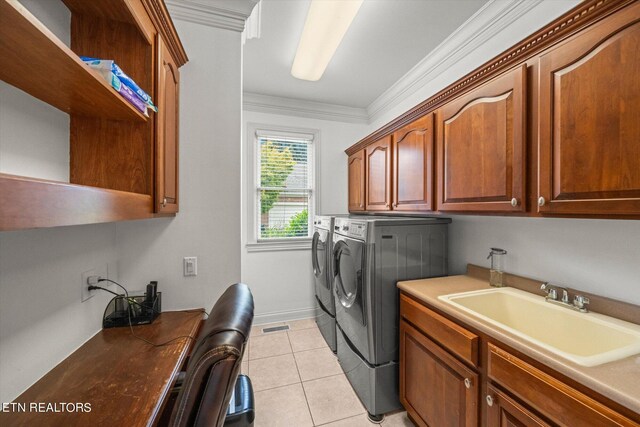 clothes washing area featuring separate washer and dryer, cabinets, sink, and ornamental molding