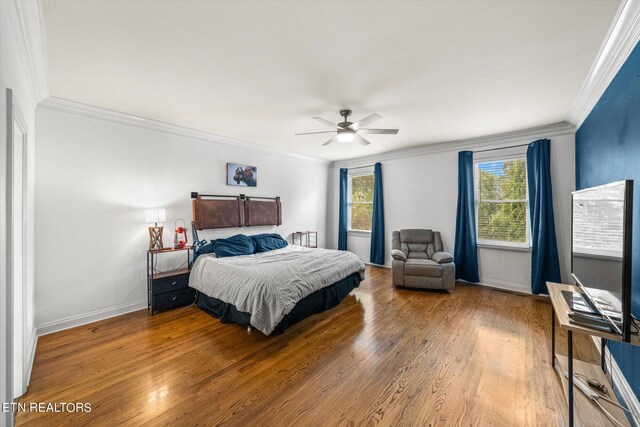 bedroom with wood-type flooring, ornamental molding, and ceiling fan