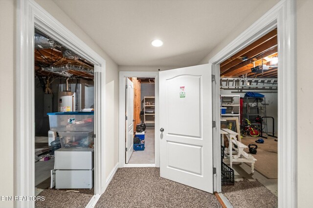 hallway featuring water heater and carpet flooring