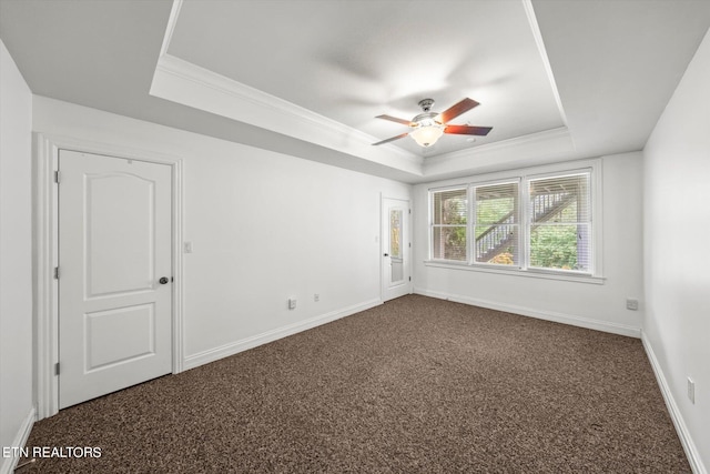 carpeted spare room featuring a raised ceiling, crown molding, and ceiling fan