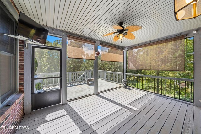 unfurnished sunroom featuring ceiling fan