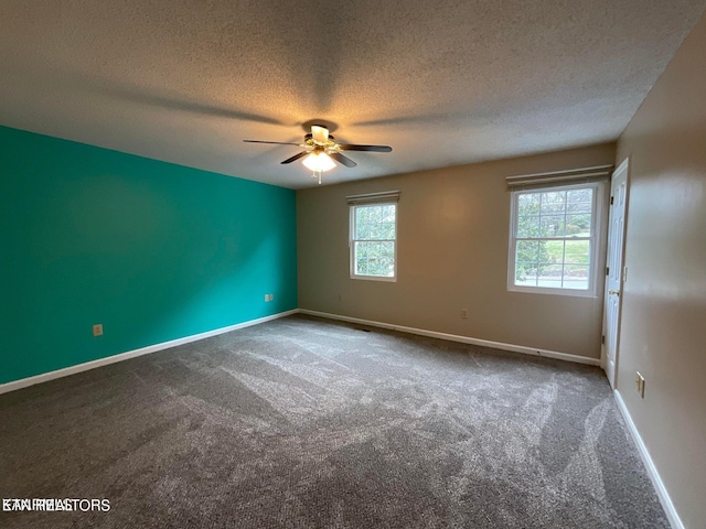 carpeted empty room featuring a textured ceiling, a healthy amount of sunlight, and ceiling fan