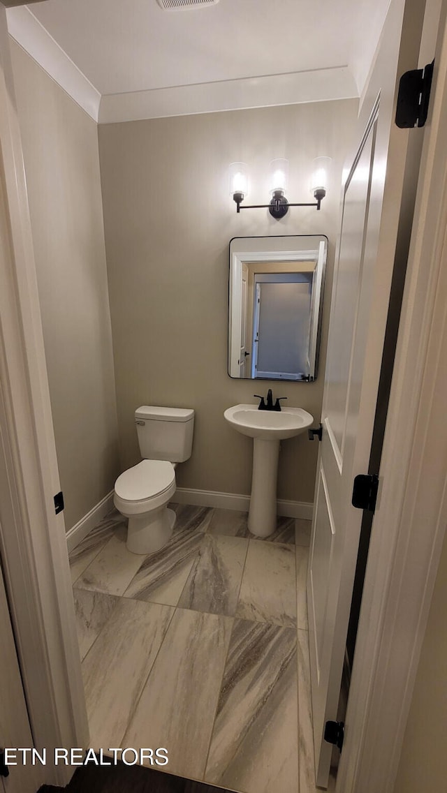 bathroom featuring toilet and ornamental molding