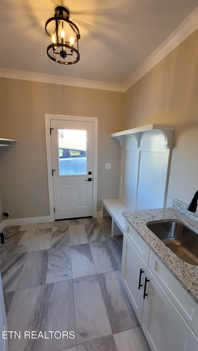 interior space featuring ornamental molding, sink, and a chandelier