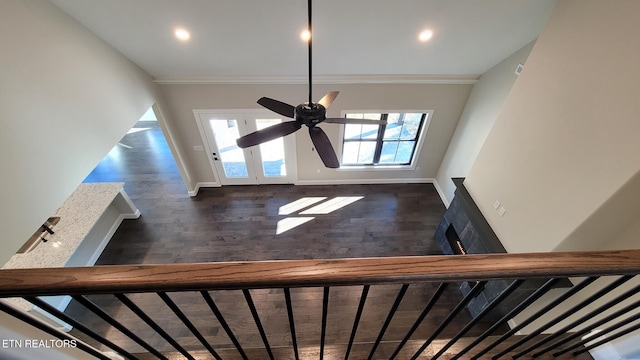 stairway with ceiling fan, wood-type flooring, and ornamental molding