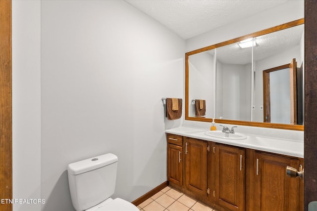 bathroom featuring tile patterned flooring, toilet, a textured ceiling, and vanity