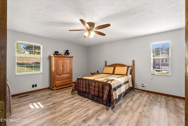 bedroom featuring multiple windows, ceiling fan, and light hardwood / wood-style floors