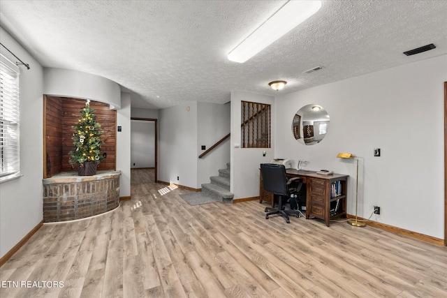 office space with light hardwood / wood-style floors and a textured ceiling