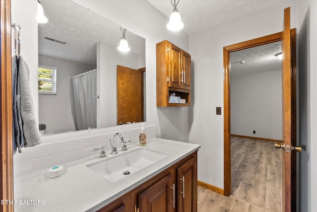 bathroom featuring vanity, a textured ceiling, and wood-type flooring