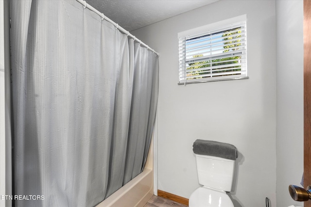 bathroom featuring toilet and shower / bath combination with curtain