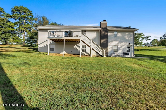 back of house featuring a lawn and a wooden deck