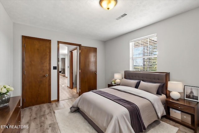 bedroom featuring light wood-type flooring and a textured ceiling