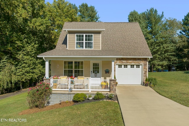 view of front of home featuring a garage, a front yard, and a porch