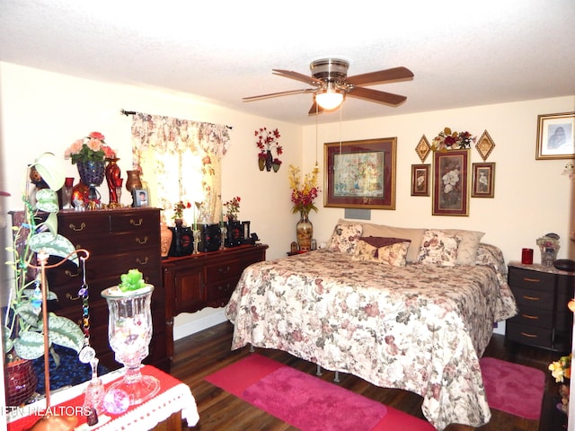 bedroom featuring dark wood-type flooring, ceiling fan, and a textured ceiling