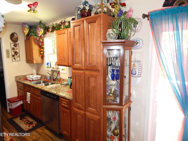 kitchen featuring stainless steel dishwasher, light stone countertops, dark hardwood / wood-style floors, and sink