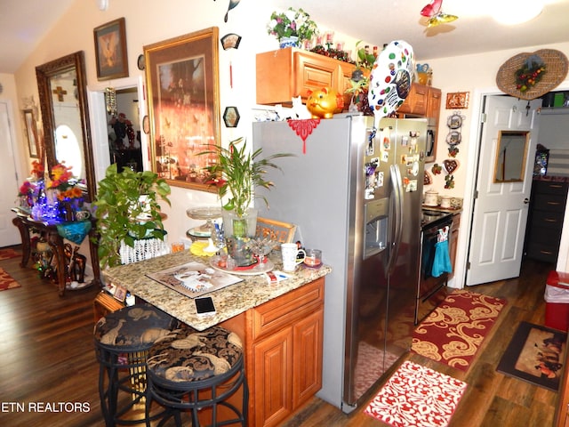 kitchen with light stone counters, stainless steel fridge with ice dispenser, dark wood-type flooring, lofted ceiling, and black range with electric stovetop