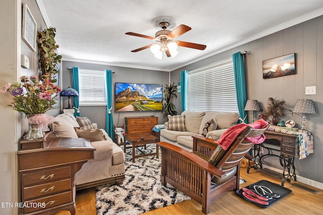 living room featuring crown molding, light hardwood / wood-style flooring, and ceiling fan