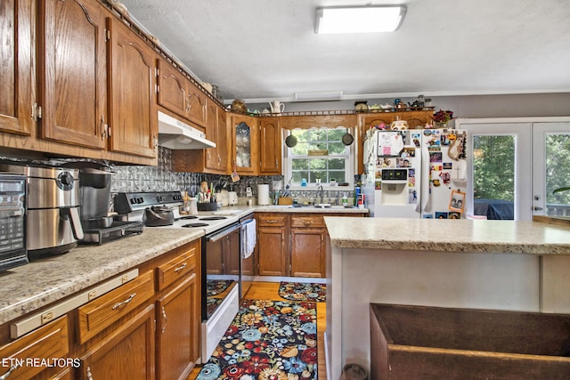 kitchen with white appliances, a healthy amount of sunlight, backsplash, and a textured ceiling