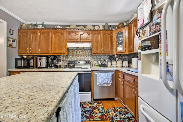 kitchen featuring crown molding, a textured ceiling, white appliances, light hardwood / wood-style flooring, and tasteful backsplash