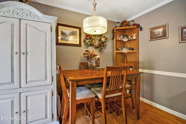 dining area featuring crown molding and hardwood / wood-style floors