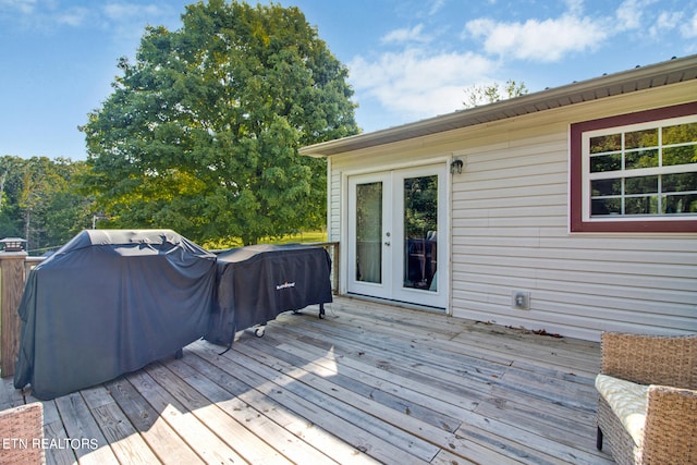 wooden deck with a grill and french doors