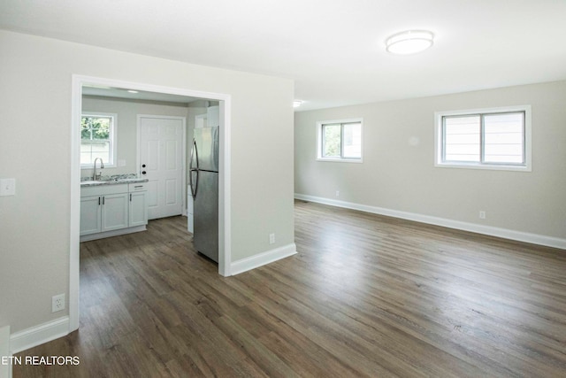 spare room with a wealth of natural light, dark hardwood / wood-style floors, and sink