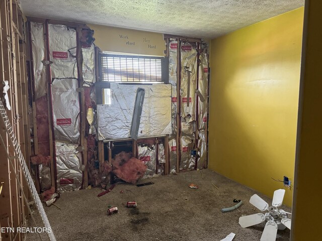 unfurnished bedroom with a textured ceiling, carpet, and ceiling fan